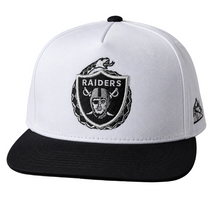 Load image into Gallery viewer, A white and black Oakland Raiders snapback cap featuring a large black embroidered Raiders logo on the front and a small New Era flag logo on the side, set against a neutral gray background.